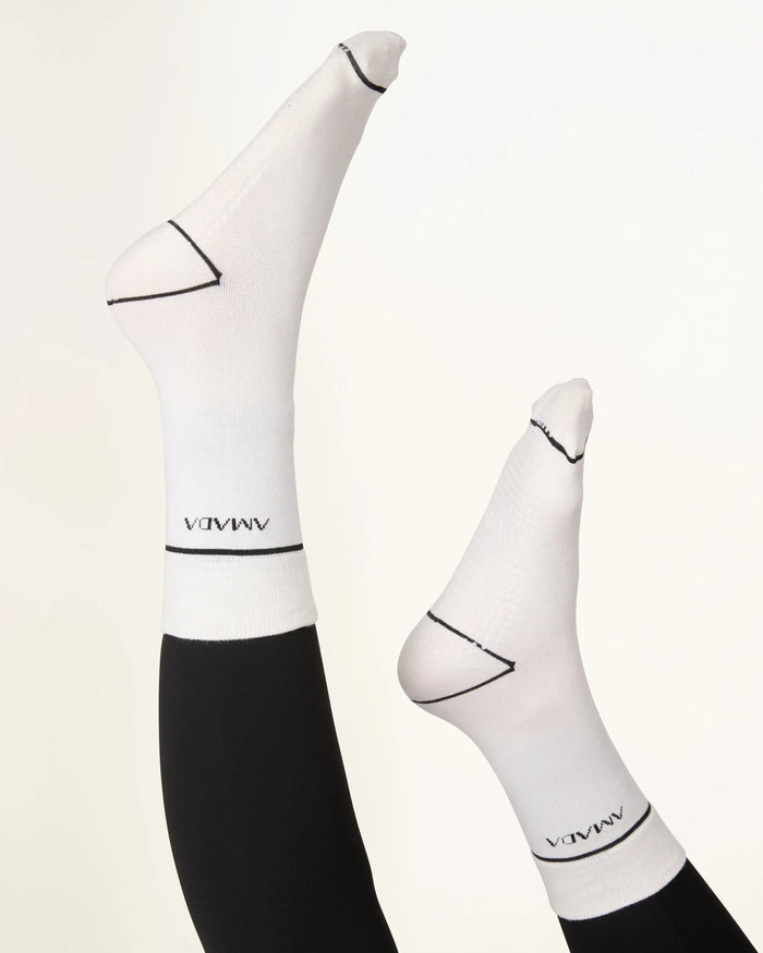 White socks with black accents and 'AMVA' branding on a light background